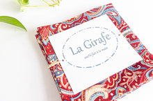 Load image into Gallery viewer, A Set of 4 Red Paisley Napkins folded in a square
