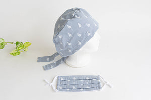 Side view of Cloth scrub hat with White Flamingo pattern on light Grey with a matching face mask