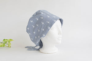 Side view of Cloth scrub hat with White Flamingo pattern on light Grey ground