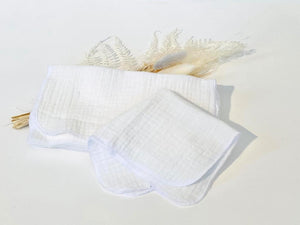 A stack of 12 white cotton handkerchiefs