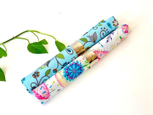 Tow rolled napkins one with a Floral pattern on Blue ground, one with a Japanese Umbrellas pattern