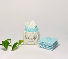 Charger l'image dans la galerie, Ivory cotton pouch printed with La Girafe Couture and a stack of Aqua printed makeup remover pads