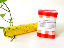 Charger l'image dans la galerie, A stack of folded towels and one rolled with Plaids, Circles and Floral patterns in bright colours