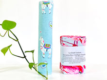 Charger l'image dans la galerie, A stack of folded towels with Flamingo, Lamas and Polka Dots patterns next one rolled towel