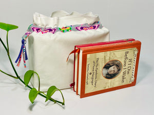 One big bag in off-white cotton canvas with a Butterfly trim next to a book