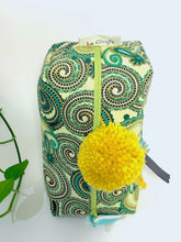 Load image into Gallery viewer, Top view of rectangular Cosmetic bag with Green Paisley printed pattern and Yellow Pompon