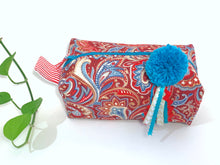 Load image into Gallery viewer, Top view of rectangular cloth cosmetic bag with zipper, Red Paisley pattern and Blue Pompon
