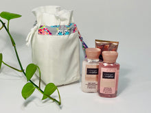 Charger l'image dans la galerie, One small bag in off-white cotton canvas with a Butterfly trim next to 3 small bottles of lotion