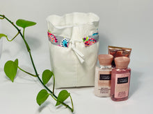 Charger l'image dans la galerie, One small bag in off-white cotton canvas with a Butterfly trim next to 3 small bottles of lotion