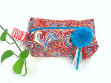 Load image into Gallery viewer, Top view of rectangular cloth cosmetic bag with zipper, Red Paisley pattern and Blue Pompon