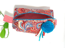 Load image into Gallery viewer, Top front view of rectangular cloth cosmetic bag with zipper, Red Paisley pattern and Blue Pompon