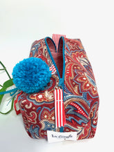 Load image into Gallery viewer, Top front view of rectangular cloth cosmetic bag with zipper, Red Paisley pattern and Blue Pompon