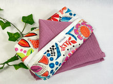 Load image into Gallery viewer, Cotton dispenser box in a brightly coloured pattern with 12 Pink cotton handkerchiefs folded inside
