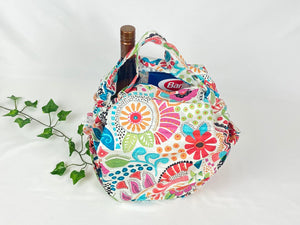 Cotton bag with handle with a floral pattern with vibrant colors with grocery in it