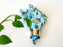 Load image into Gallery viewer, One folded napkin in a triangular shape with a Floral pattern on Blue Ground

