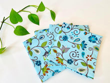 Load image into Gallery viewer, Four folded napkins with a Floral pattern on Blue ground
