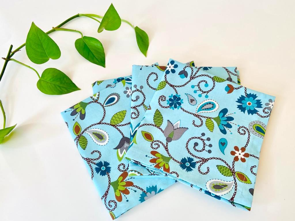 Four folded napkins with a Floral pattern on Blue ground