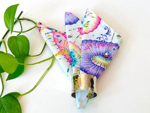 One folded napkin in a triangular shape with a Japanese Umbrellas pattern on White Ground