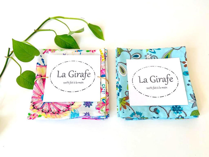 Two set of folded table napkins one with Japanese Umbrellas pattern and one with Blue Floral pattern