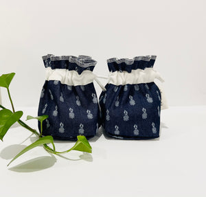 Two Pouches made of Denim with Pineapple pattern with a stack of white makeup remover pads