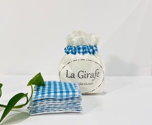 Ivory pouch printed with La Girafe Couture logo with a stack of Blue Checkered makeup remover pads