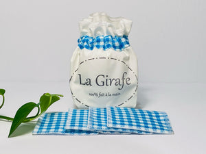 Ivory pouch printed with La Girafe Couture logo with a stack of Blue Checkered makeup remover pads