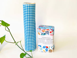 A stack of folded towels with Butterfly, Checks and Garden patterns with a rolled towel
