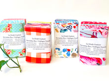 Load image into Gallery viewer, Four stacks of folded towels in a range of patterns in a large assortment of colours
