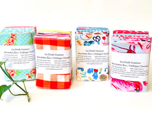 Four stacks of folded towels in a range of patterns in a large assortment of colours