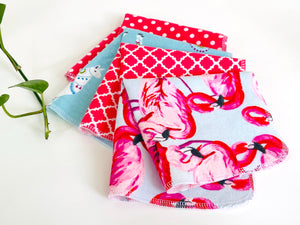 Four folded towels with Flamingo, Lamas and Polka Dots patterns in Pink and Blue