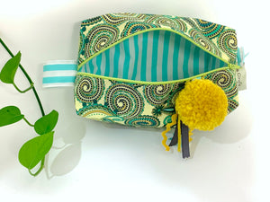 Top view of rectangular Cosmetic bag with Green Paisley printed pattern and Yellow Pompon