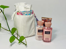 Charger l&#39;image dans la galerie, One small bag in off-white cotton canvas with a Butterfly trim next to 3 small bottles of lotion
