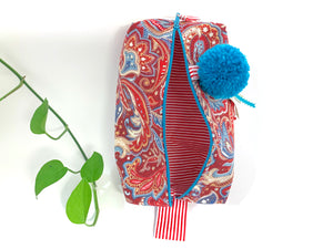 Top  view of rectangular cloth cosmetic bag with zipper, Red Paisley pattern and Blue Pompon