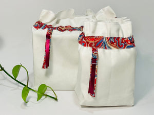 Two bags in off-white cotton with a Red Paisley trim. One bag is big and one small.