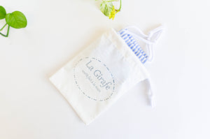 Ivory Cotton pouch with 100% handmade printed logo and containing a folded cotton face mask