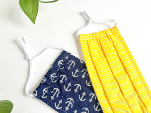 Two face masks, one Navy ground with Silver Anchor print, One Yellow ground and White tiny Dots
