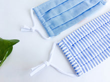 Load image into Gallery viewer, Closeup of two face masks one Solid Blue and one Blue and White Stripes
